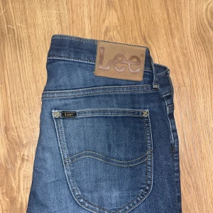 Blå jeans från Lee - Snygga blå jeans från Lee. Dem är slimfit och väldigt bra skick men man kan se tecken på användning på t.ex. baksidan. Skriv för fler frågor.