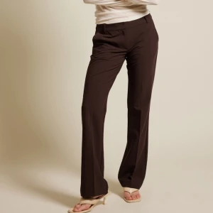 Bruna kostymbyxor - Snygga bruna kostymbyxor med en klassisk bootcut-stil. Dessa byxor är lågmidjade och ser ut precis som på bilden. 