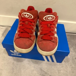 Röda Adidas Campus sneakers - Snygga röda Adidas Campus sneakers med vita och röda nya snören. Skorna är i bra skick. Pris kan diskuteras 