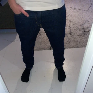 Mörkblå jeans - Snygga mörkblå jeans med en klassisk passform. De har en midwaist och raka ben, vilket ger en tidlös look. Perfekta för både vardag och mer uppklädda tillfällen. W31 L32 slim passform