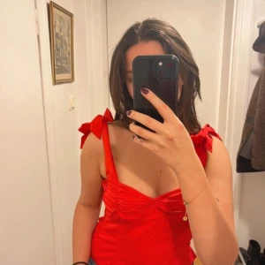 Röd topp rosetter - Så fin och söt topp med rosetter som man kan knyta upp och justera längden med! ❣️ strl 8 men passar en S och XS pga resåren i ryggen