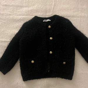 Stickad kofta Zara - ”Kraftigare/fluffigare” stickad kofta med trekvartsärmar från Zara. Använts fåtal gånger så bra skick ( förutom en knapp som saknas)! 