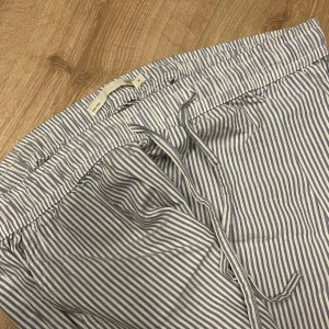 Randiga byxor med snörning - Randiga pyjamasbyxor i blått och vitt med snörning 