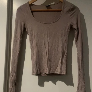 Soft tuch gina tricot - Säljer en stilren beige långärmad topp med rund halsringning. Perfekt för lager-på-lager eller som den är. Passar till både jeans och kjol. Slit ärm