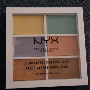 Color Correcting Concealer från NYX - Färgkorrigerande concealerpalett från NYX med sex olika nyanser för att neutralisera och dölja ojämnheter. Innehåller gula, gröna, lila och orange toner för att täcka mörka ringar, rodnad och andra hudproblem. Oanvänd, prislapp saknas.