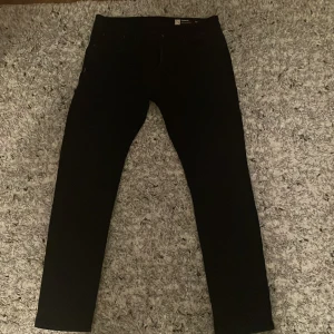 Svarta jeans från Chasin' - Snygga svarta jeans från Chasin' med en tapered fit. Perfekta för en stilren look. Tillverkade i denim med klassisk design och märkets logga på baksidan.