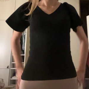 Svart v-ringad topp - Snygg svart v-ringad topp med korta ärmar. Perfekt för en stilren look. Passar bra till både jeans och kjol.