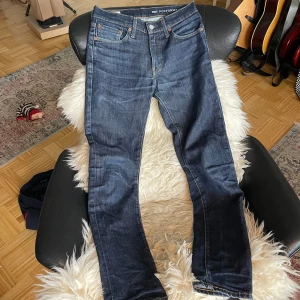 Levis 511 Jeans - Flitigt använda 511:or som är lagade på vänster baksida. Övrigt slitage är bruks slitage såsom bleknad på bakfickorna. Storlek: W29 L32