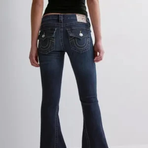True Religion Jeans - Populära utsvängda jeans från True Religion med låg midja. Stretchigt material med låg midja. Figurnära passform upptill med utsvängda ben, bakfickor med ficklock och knapp. Dragkedjegylf med knapp. Älskar dessa men lite långa på mig. Nypris 1299kr. Nästan oanvända💕