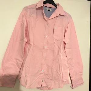 Skjorta rosa - Rosa skjorta med vita detaljer från kappahl storlek 36. Fint skick trots att den använts en del. Figursydd modell