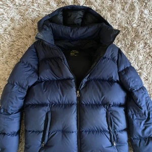 Ralph Lauren jacka - Säljer min Ralph Lauren jacka i blå.  Lite rött på ena armen, men annars fint skick. Stor, varm perfekt för vintern🌨️. Passar bra för s/xs. Köpt här på Plick och använd under en vinter. Skriv för fler bilder🤍💙OBS: Vet ej om den är äkta då köpt här!