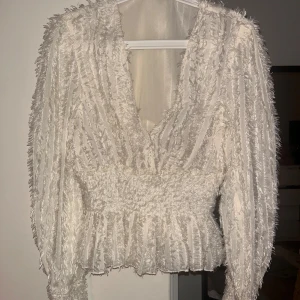 Vit topp med långa ärmar  - En superfin festlig topp från Nakd. Använd 1 gång, som ny. Strl 40