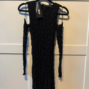Svart klänning  - Säljer en superfin svart klänning, offshoulder-design med långa ärmar och en tight passform som  framhäver figuren. Ny med prislapp kvar!