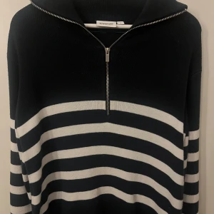 Randig tröja - En snygg tröja från märket Kappahl i storlek S. Tröjan har ett stilrent randigt mönster i svart och vitt med en dragkedja framtill. Perfekt för både vardagsbruk och avslappnade tillfällen. Bra skick och passar till olika outfits!