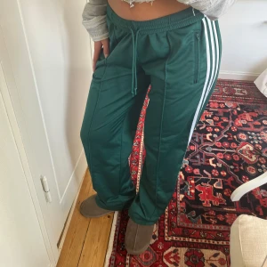 Adidas byxor  - Adidasbyxor med fickor och dragkedja ner till ifall man vill ha slit💚 midjekanten går att ha både nervik för att bära lågmidjat, (som på bilderna) eller uppvikt så hamnar snörningen inåt. 