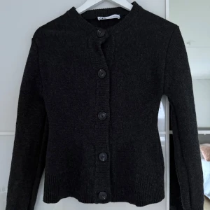 Cardigan i 100%  - Jättefin grå cardigan i 100% ull från Zara. I mycket bra skick då den endast är använd ett fåtal gånger. Åtsittande och figursydd. Storlek S. Nypris 799 kr. 