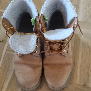 Bruna kängor från Timberland - Säljer ett par bruna kängor från Timberland i bra skick. De är gjorda av mocka och har en mysig fodring som passar perfekt för höst och vinter. Skorna har snörning och en robust sula som ger bra grepp. Perfekta för kalla dagar! 🌲