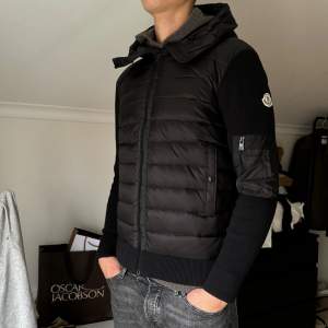 Säljer en snygg svart dunjacka från Moncler i mycket bra skick. Jackan har en stilren design med dragkedja och en praktisk huva. Perfekt för höst och vinter, håller dig varm och trendig. Passar både till vardags och lite finare tillfällen. Storlek large men passar bra till medium, kvittot kan tilldelas privat. Mvh Axel