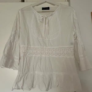 Vit blus med spets  - Vit blus med spets detaljer och trekvarts ärm. 