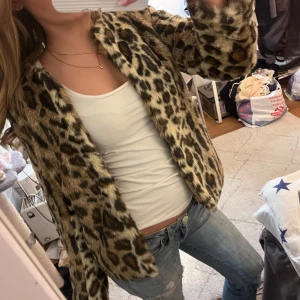 Leopardmönstrad pälsjacka från terranova  - Säljer en supercool leopardmönstrad pälsjacka från terranova. Den är i mycket bra skick och perfekt för höst och vinter. Jackan har långa ärmar och en normal passform. Den är gjord av syntetmaterial och är riktigt mjuk och skön. Perfekt för att sticka ut på festen eller bara känna sig extra glamorös!