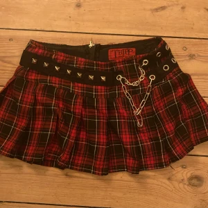 Rutig kortkjol från Tripp - säljer en kjol från tripp nyc!! kjolen har nitar och kedjedetaljer, den har en dragkedja bak också. skriv för mått 🖤