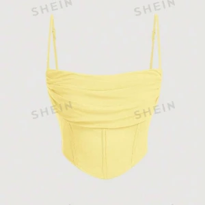 Gul korsettopp  - Snygg gul korsettopp med smala axelband och en draperad framsida. Perfekt för sommardagar eller en festkväll. Toppen har en figurnära passform som framhäver midjan.