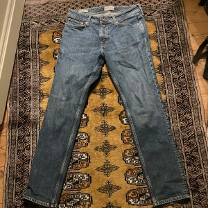 Jack & Jones jeans - Säljer ett par klassiska blå jeans i bra skick. De har en straight passform och är tillverkade i denim. Perfekta för vardagsbruk och kan matchas med det mesta. Modellen är Slim Straight / Tim