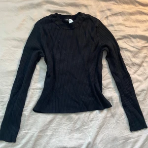 Svart ribbad långärmad tröja - Säljer en stilren svart ribbad tröja med långa ärmar. Perfekt för både vardag och fest. Tröjan har en tight passform som framhäver figuren. Passar bra till både jeans och kjol. 🖤 skriv för fler bilder eller frågor. står M på den men passar S också