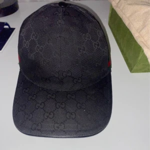 Svart Gucci keps - Säljer en svart Gucci keps. Den är i bra skick, köptes 2023. Kvitto finns, dustbag finns och allt som kom med. Storlek Medium
