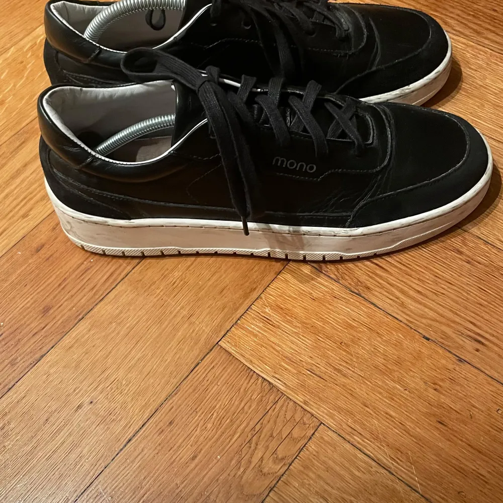 Snygga svarta sneakers i skinn från det norska märket Mono. De har en klassisk design med vita sulor och svarta snören. Perfekta för både vardag och fest. Skorna är i mycket bra skick och passar till de flesta outfits. Köpte för 2000. Skor.