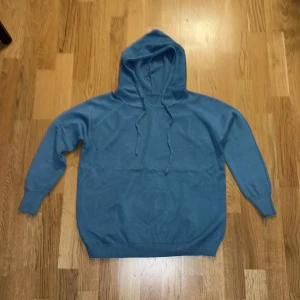 Blå hoodie i merinoull - Säljer en snygg blå hoodie i merinoull (100% merinoull). Den har en klassisk design med dragsko i huvan och ribbade muddar vid ärmslut och nederkant. Perfekt för en avslappnad stil och passar bra till både höst och vår. Skön och enkel att matcha med det mesta i garderoben! Den är helt ny och säljes Pga felköp av storlek. Storlek Small men passar även Xs. (någon runt 170-175) Kom jätte gärna med prisförslag. 