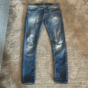Blå jeans med slitningar - Säljer ett par snygga blå Dondup jeans. Jeansen är i bra skick 9/10. George är modellen. 