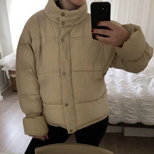 Beige pufferjacka - Säljer en supermysig beige pufferjacka i bra skick. Den har en hög krage och knappar framtill. Perfekt för kalla höst- och vinterdagar. Jackan är oversized och ger en cool look. Passar perfekt till både vardag och chill dagar. 🧥✨
