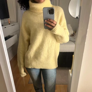 Gul stickad polotröja - Mysig gul stickad polotröja med hög polokrage och långa ärmar.