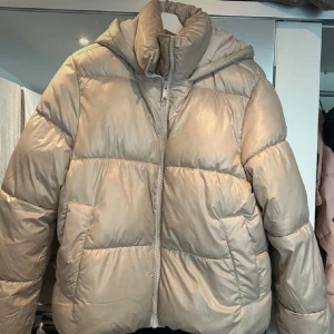 Beige pufferjacka från H&M - Säljer en supermysig beige pufferjacka från H&M i storlek M. Perfekt för kalla dagar med sin tjocka vaddering ❄️