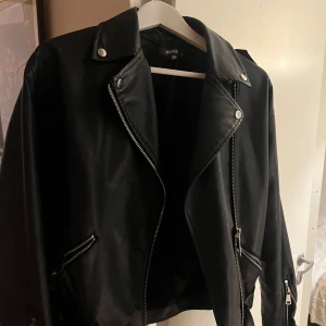 Svart skinnjacka från Missguided  - Säljer en snygg svart skinnjacka från Missguided i storlek S. Jackan har silver dragkedjor och knappar som detaljer. Perfekt för höst och vår, och har en liten oversized stil🤍