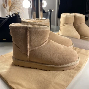 Beige boots från UGG - Säljer ett par supermysiga ljus beiga boots från UGG i nytt skick. De är gjorda av mocka och har en fluffig insida som håller fötterna varma under kalla dagar. Perfekta för höst och vinter! 🧡 nytt skick aldrig använda! Äkta.