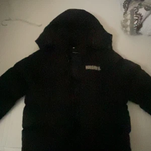 Svart pufferjacka från Hoodrich - Säljer en svart pufferjacka från Hoodrich i storlek M. Jackan är perfekt för kalla dagar med sin tjocka vaddering och har en stilren design med Hoodrich-loggan på bröstet och ryggen. Den har en dragkedja framtill och är långärmad. Perfekt för vintern! ❄️