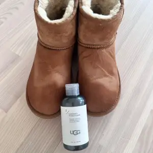 Säljer ett par bruna UGG boots i bra skick. De är fodrade med mjukt fårskinn som håller fötterna varma under kalla dagar. Perfekta för höst och vinter! Inkluderar en flaska UGG Cleaner & Conditioner för att fräscha upp dem och få bort vattenfläckaran, originalmedel. Säljes i befintligt skick.