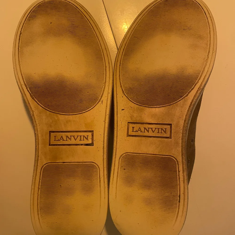 Säljer ett par grå sneakers från Lanvin i bra skick. De enda defekterna är att sulan är sliten se bild. Storleken är 42 men skon är stor i storleken. Pris ej hugget i sten.. Skor.