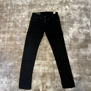 Svarta jeans DONDUP - Säljer ett par svarta jeans i bra skick. De har en snygg knappgylf och klassisk femficksdesign. Perfekta för både vardag och fest! Passar dig som gillar en tight passform.