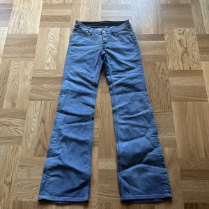 lågmidjade bootcut jeans - Säljer ett par snygga blå byxor från Filippa K i mycket bra skick. De har en klassisk lågmidjad bootcut-stil och är perfekta för både vardag och fest. Storlek 27! mått: midja-35cm, innerbenslängden-84cm, grenmåttet-19cm