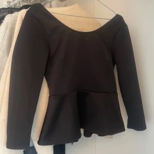 Svart topp med rosett detalj - Så snygg svart topp med peplum och en rosett i ryggen. Den har en öppen v-ringad rygg. Perfekta festtoppen men går även att klä ner och ha när som helst. Vill se hur mycket jag kan få för den därav priset! ❣️