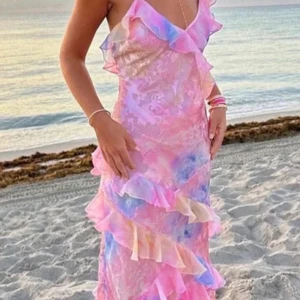 Färgglad långklänning med volanger - Säljer en superfin långklänning i härliga pastellfärger som rosa, blå och lila. Klänningen har volanger och perfekt för sommarens fester eller en dag på stranden. Den är även perfekt för midsommar 💕