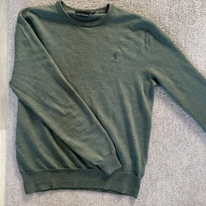 Ralph Lauren tröja - Tjena! Säljer nu en snygg grön tröja från Polo Ralph Lauren i 100% merinoull. Den är i bra skick och perfekt för höst och vinter. Tröjan har långa ärmar och ribbade muddar vid ärmslut och nederkant. Perfekt för en stilren look! 🍂