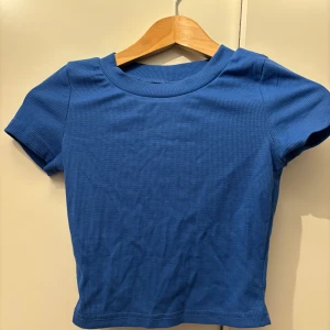 Blå ribbad topp från Shein - Säljer en snygg blå ribbad topp från Shein i storlek XS. Den har en tight passform och korta ärmar, perfekt för sommardagar eller som ett basplagg i garderoben. Toppen är i mycket bra skick och redo för nya äventyr! 💙