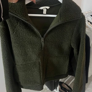 Mörkgrön teddyjacka - Säljer en mysig mörkgrön teddyjacka med dragkedja framtill. Perfekt för höst och vinter, som håller dig varm. Den är i storlek xs men känns mera som en S💕