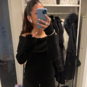 Svart offshoulder tröja - Säljer en stilren svart offshoulder tröja som är perfekt för både vardag och fest. Tröjan har långa ärmar och en tight passform som framhäver figuren. Den är superbekväm och lätt att matcha med olika outfits. Perfekt för höst och vinter!