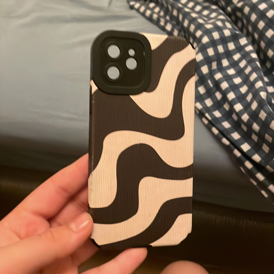 Svart och beige mobilskal med vågigt mönster. Till en ipohne 12