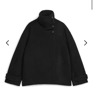 Arket kappa - Säljer en stilren svart kappa i mycket bra skick. Den har en klassisk design med knappar framtill och långa ärmar. Perfekt för höst och vinter, och passar både till vardags och fest. Storleken är 34 , den är från Arket
